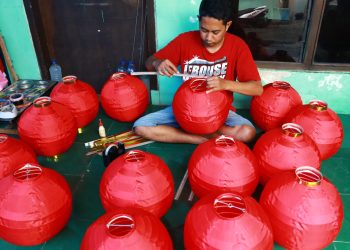 Seorang pekerja memproduksi Lampion di Kampung Lampion ,Jodipan Kota Malang.Kamis (24/11/2032).