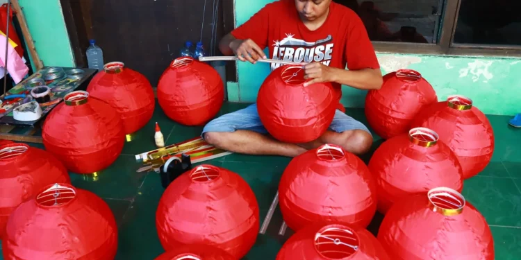 Seorang pekerja memproduksi Lampion di Kampung Lampion ,Jodipan Kota Malang.Kamis (24/11/2032).