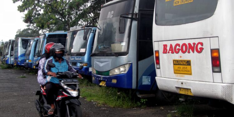 Bus Bagong parkir dekat Bus Puspa Indah yang sudah mangkrak di Terminal Landungsari, Kota Malang.