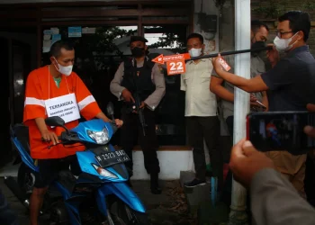 Tersangka saat reka adegan dalam rekontruksi dugaan tindak pidana pembunuhan nenek 85 tahun oleh anak angkatnya yang terjadi pada 24 November 2022 di Jl Manyak 36 Sukun, Selasa (13/11/2022),