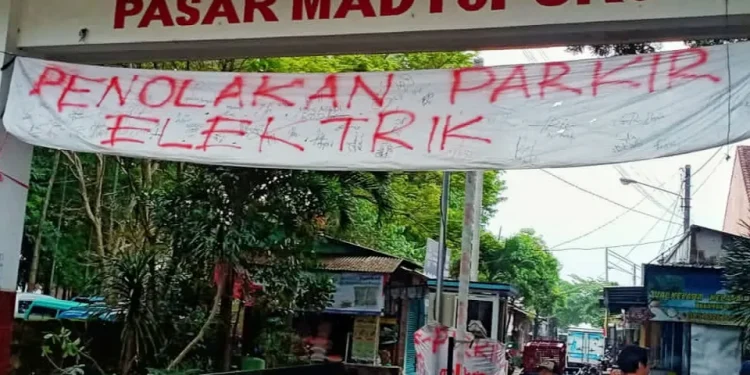 Spanduk penolakan atas rencana penerapan E-Parking di Pasar Madtopuro, Kota Malang.