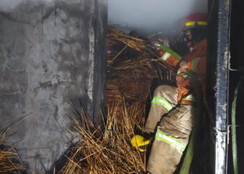 Petugas melakukan penanggulangan kebakaran di oven tusuk sate.