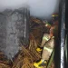 Petugas melakukan penanggulangan kebakaran di oven tusuk sate.