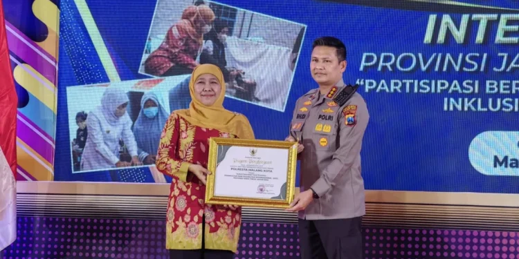 Gubernur Jawa Timur Khofifah Indar Parawansa menyerahkan penghargaan kepada Kapolresta Malang Kota Kombes Pol Budi Hermanto.
