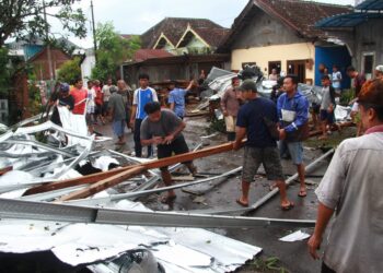 Atap sebuah pertokoan selebar 300 M2 Terbawa angin 3 Rumah warga warga bergotong royong evakuasi atap galvalum di Griya asri Katon, di desa Asrikaton, kec.pakis , Kamis(15/12/2022) Malang.