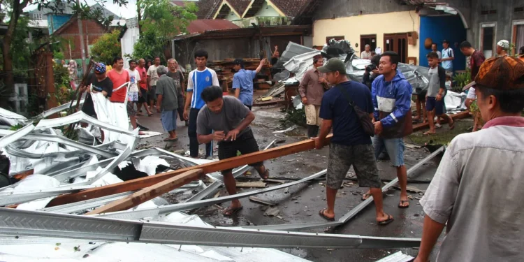 Atap sebuah pertokoan selebar 300 M2 Terbawa angin 3 Rumah warga warga bergotong royong evakuasi atap galvalum di Griya asri Katon, di desa Asrikaton, kec.pakis , Kamis(15/12/2022) Malang.