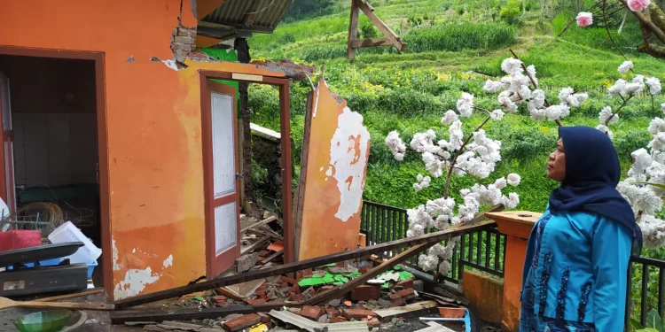 Kepala Sekolah SDN Satu Atap Gunungsari, Siti Roihatul Hasanah, menunjukkan bangunan toilet yang ambrol tak bersisa imbas dari pergerakan tanah dibawahnya yang tak stabil.