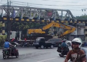Kondisi truk pengangkut alat berat tersangkut jembatan perlintasan kereta api atau Buk Glodok, Kota Malang.