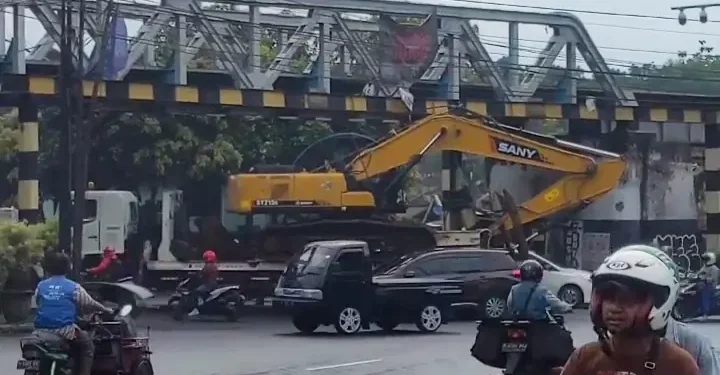 Kondisi truk pengangkut alat berat tersangkut jembatan perlintasan kereta api atau Buk Glodok, Kota Malang.