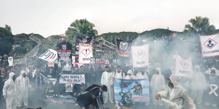 Aremania saat melakukan aksi teatrikal dalam menuntut keadilan bagi korban Tragedi Kanjuruhan.