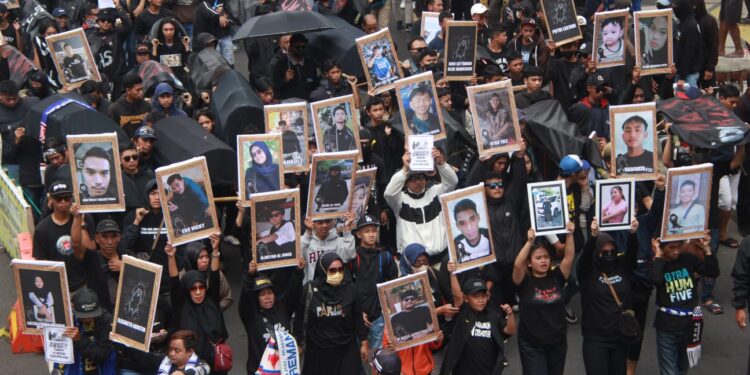 Aremania melakukan aksi menuntut keadilan bagi korban Tragedi Kanjuruhan.