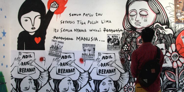 Pengunjung melihat karya mural grafiti dalam pameran seni rupa di gedung Dewan Kesenian Malang (DKM). Kegiatan ini untuk memperingati 100 Hari Tragedi Kanjuruhan pada Selasa (10/1/2023).