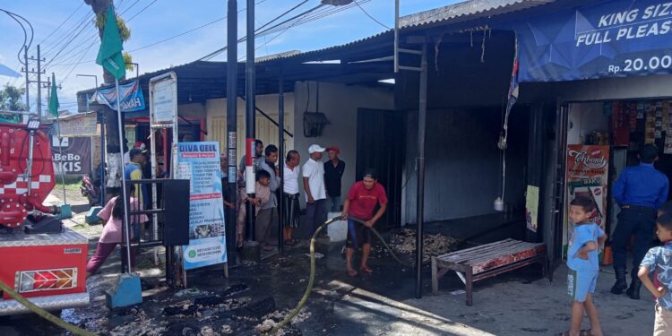 Petugas Damkar Kabupaten Malang melakukan penanggulangan kebakaran di kios handphone dan bensin di Pakis.