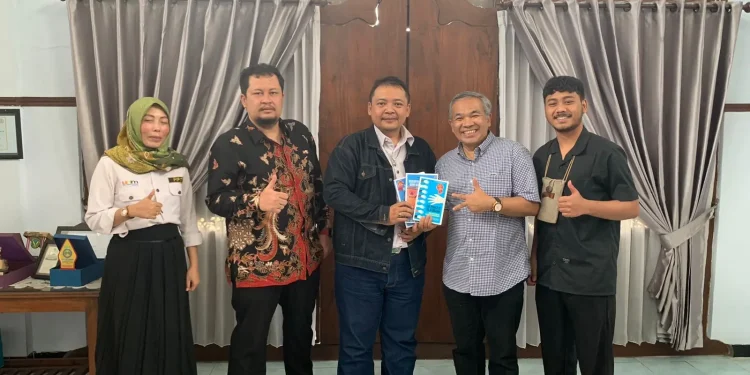 Pakar Komunikasi dan Motivator Nasional, Dr Aqua Dwipayana, memberikan buku.