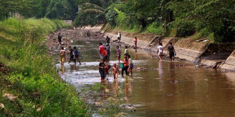Sejumlah warga Kota Malang mencari ikan di sungai Telogowaru yang surut akibat penutupan Bedungan Kali Amprong Rolak, Kelurahan Kedungkandang, Kota Malang pada Kamis (16/1/2023).