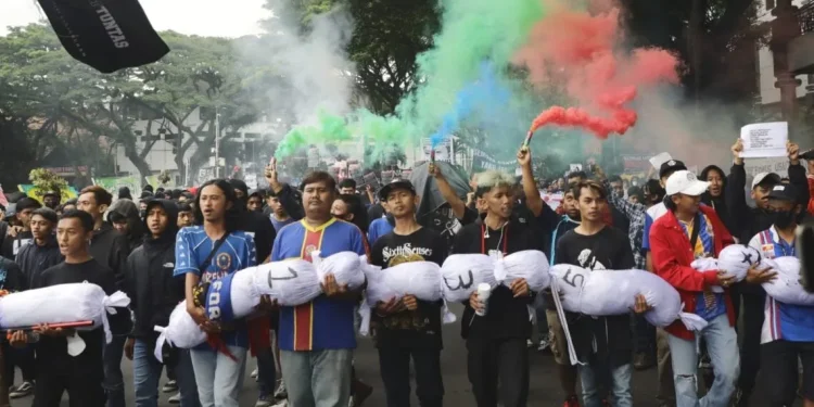 Ratusan Aremania turun ke jalan membawa jenazah simbolik untuk menunut pertanggungjawaban atas kematian 135 korban jiwa dalam Tragedi Kanjuruhan.