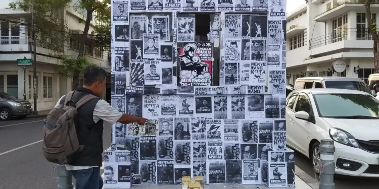 Pos polisi lalu lintas yang berada di Simpang Empat Rajabally Kayutangan Kota Malang kini tertutup penuh oleh berbagai poster tuntutan usut tuntas Tragedi Kanjuruhan.