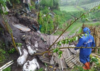 Petugas BPBD Kota Batu saat memeriksa kondisi plengsengan yang ambrol milik rumah warga di Dusun Jurangkuali, Desa Sumberbrantas, Kecamatan Bumiaji, Kota Batu.