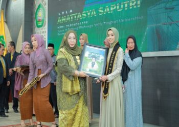 Nur Diana SE MSi, dekan FEB Unisma, memberikan penghargaan kepada wisudawan terbaik