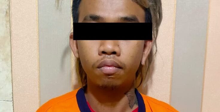 Tersangka AK (24) setelah ditahan di Polsek Singosari.
