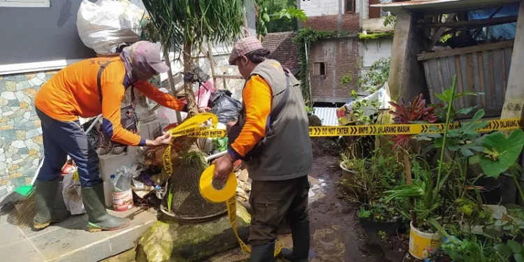 Petugas BPBD Kota Batu memberi garis pengaman agar tidak beraktivitas di belakang rumah karena rawan terjadi longsor susulan.