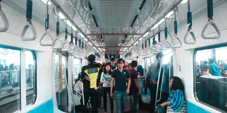 Masyarakat Indonesia berpergian menggunakan kereta.