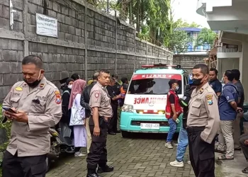 Petugas kepolisian melakukan penjagaan saat proses evakuasi jenazah korban.