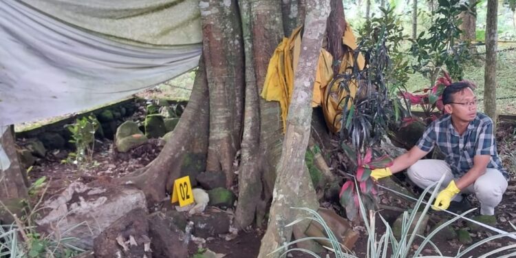 Petugas Satreskrim Polres Batu melakukan olah TKP di lokasi Arca Batara Wisnu yang hilang dicuri di komplek Candi Genter Desa Tulungrejo, Kecamatan Ngantang, Kabupaten Malang pada Selasa (21/2/2023).
