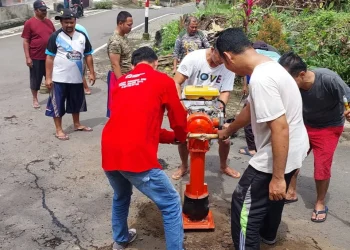 warga gotong royong tutup jalan berlubang di Perumahan Buring Raya.