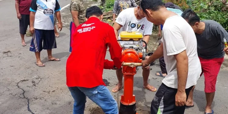warga gotong royong tutup jalan berlubang di Perumahan Buring Raya.