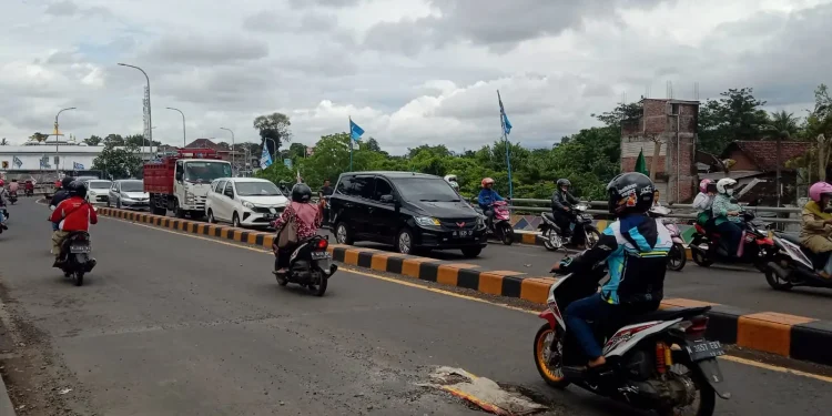 Kondisi lubang di aspal jalan di Jembatan Kedungkandang, Kota Malang yang ditutup karung berisi pasir oleh pengendara.