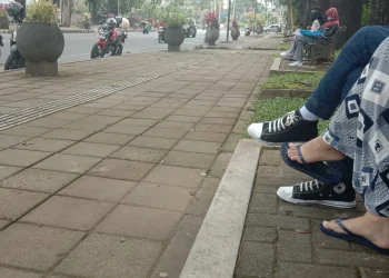 Ilustrasi sejoli duduk di kursi taman Jalan Besar Ijen, Kota Malang.