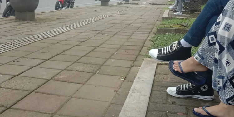 Ilustrasi sejoli duduk di kursi taman Jalan Besar Ijen, Kota Malang.
