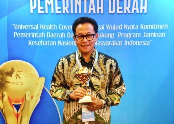 Drs. H. Sutiaji, Wali Kota Malang menunjukkan piala penghargaan UHC dari Kemenko PMK RI.
