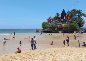 Wisatawan menikmati kunjungan mereka di Pantai Balekambang.