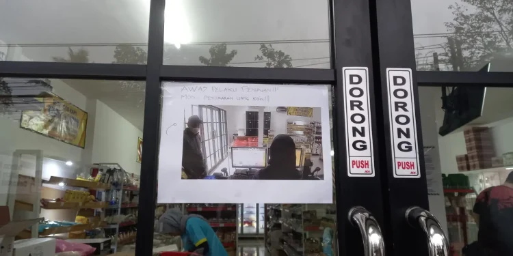 Foto pelaku dipasang di pintu masuk toko bahan kue Raja Boga.