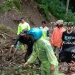 Petugas dan masyarakat melakukan pembersihan material tanah longsor.