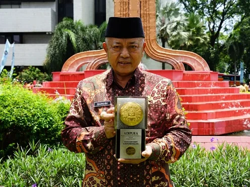 Bupati Malang, Sanusi, menunjukkan Piala Adipura yang diraihnya