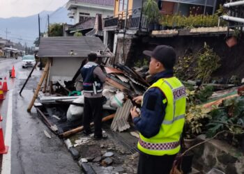 Tampak bangunan toko kelontong ambruk akibat tanah plengsengan yang juga menyangga bangunan rumah longsor, Minggu (26/3/2023). Peristiwa itu terjadi di Jalan Raya Punten Dusun Gempol, Desa Punten, Kecamatan Bumiaji.