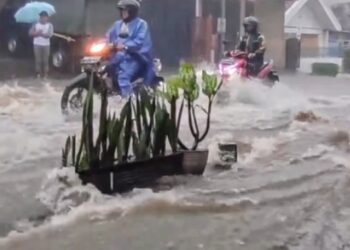 Banjir yang menggenangi jalanan saat Kota Malang diguyur hujan lebat.