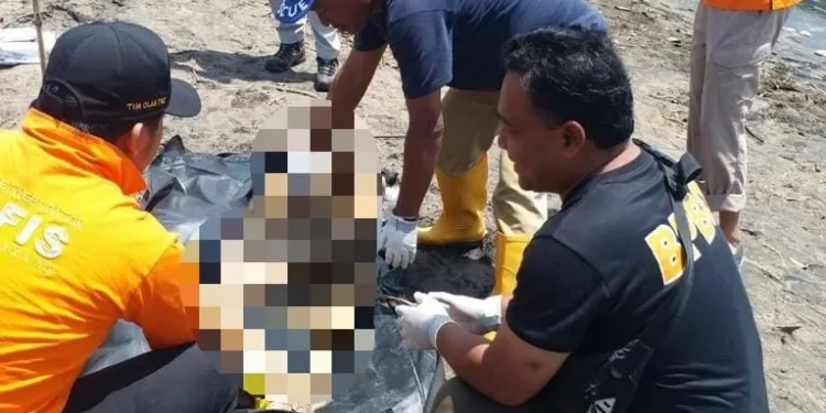 Petugas melakukan evakuasi terhadap mayat korban.