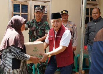 Sanusi menyerahkan bantuan kepada warga yang kurang mampu.