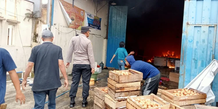 Para karyawan menyelamatkan barang-barang yang belum terbakar.