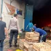 Para karyawan menyelamatkan barang-barang yang belum terbakar.