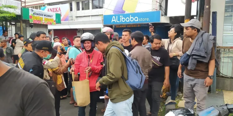 Salah seorang pedagang di Malang Plaza membawa sisa-sisa barang dagangan seperti ponsel hingga barang berharga lain yang masih bisa diselamatkan, Kamis (4/5/2023).