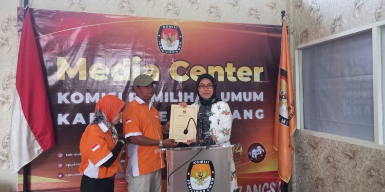 Ketua KPU Kabupaten Malang, Anis Suhartini menyerahkan tanda terima berkas pendaftaran kepada Ketua Exco Partai Buruh Kabupaten Malang, Ayub Sujatmiko. Foto: Aisyah Naw