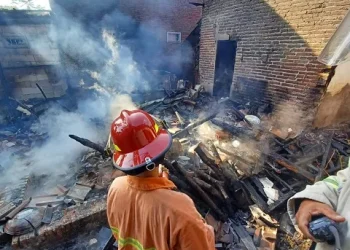 Petugas melakukan penanggulangan kebakaran di rumah milik Sumi di Pagak.