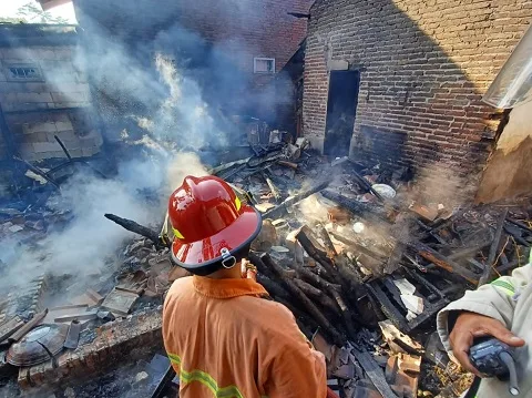 Petugas melakukan penanggulangan kebakaran di rumah milik Sumi di Pagak.