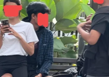 Sepasang sejoli terekam berpangkuan di kursi taman Jalan Besar Ijen, Kota Malang.