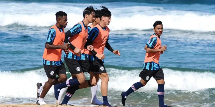 Punggawa Arema FC menjalani sesi latihan fisik di pantai.